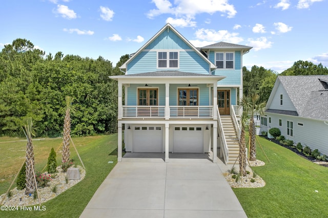 view of front of property featuring a porch, french doors, a front yard, and a garage