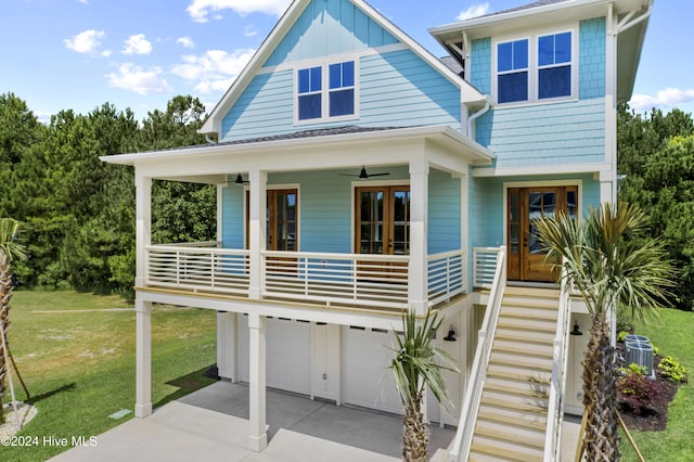 view of front of house featuring french doors, a front lawn, covered porch, and a garage