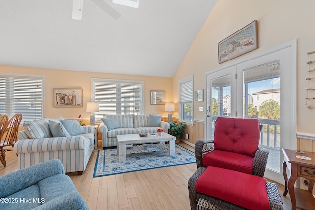 living room with light hardwood / wood-style flooring, vaulted ceiling, and ceiling fan