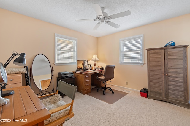 carpeted office with a textured ceiling, plenty of natural light, and ceiling fan