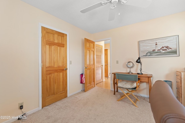 carpeted home office featuring ceiling fan