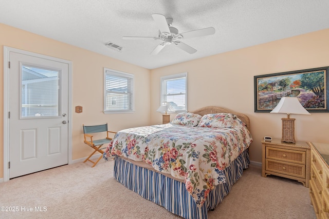 carpeted bedroom featuring ceiling fan and a textured ceiling