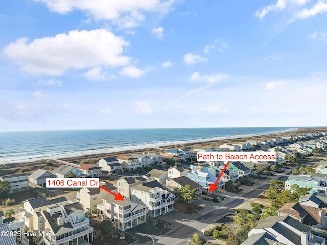 birds eye view of property with a water view and a beach view