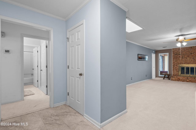 corridor with light colored carpet, ornamental molding, and a textured ceiling