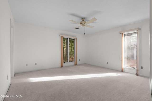 spare room with ceiling fan and light carpet