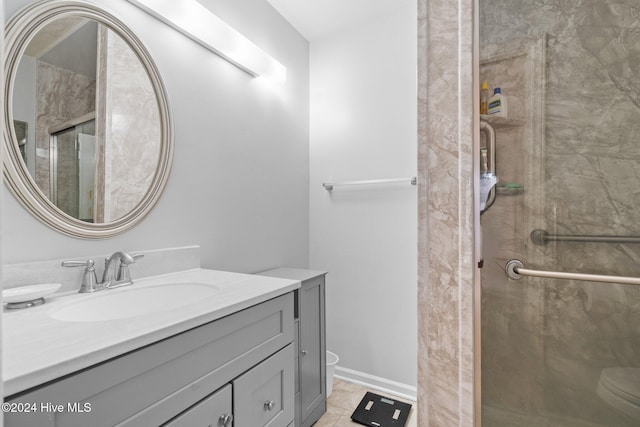 bathroom featuring tile patterned flooring, vanity, toilet, and walk in shower