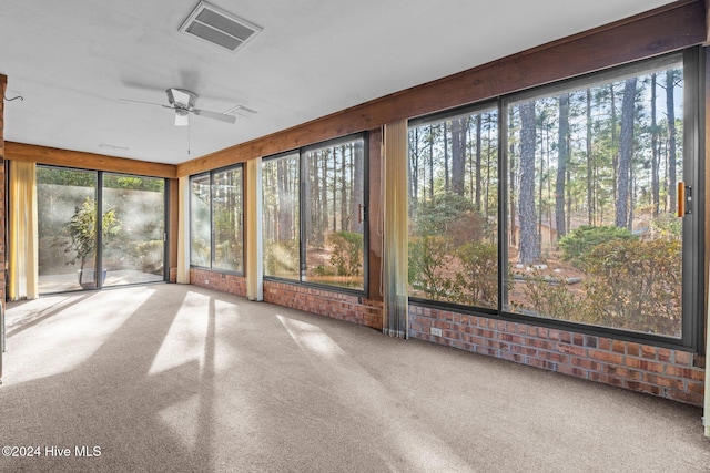 unfurnished sunroom featuring ceiling fan