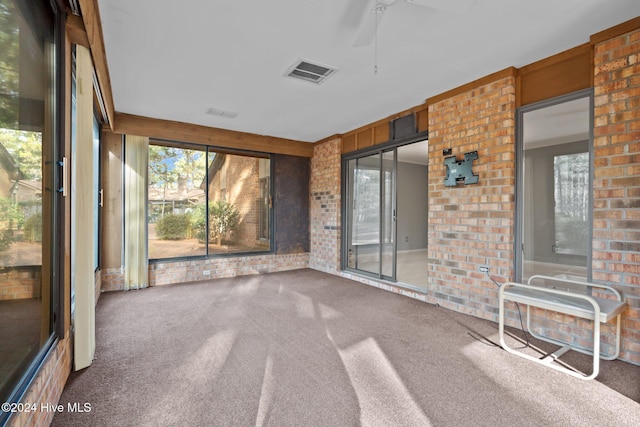 unfurnished sunroom featuring ceiling fan