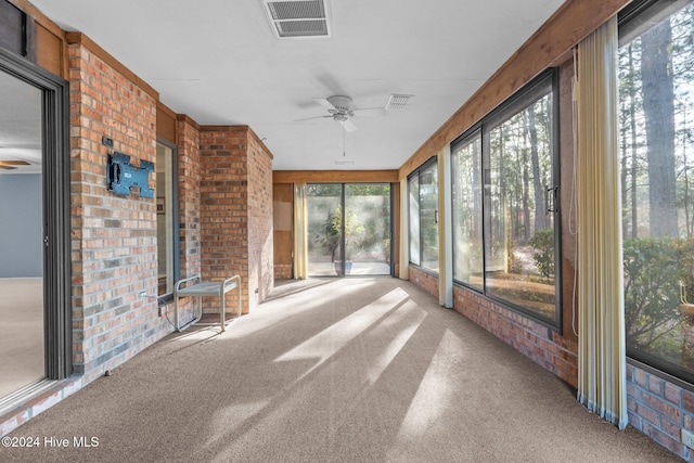 unfurnished sunroom with a wealth of natural light and ceiling fan