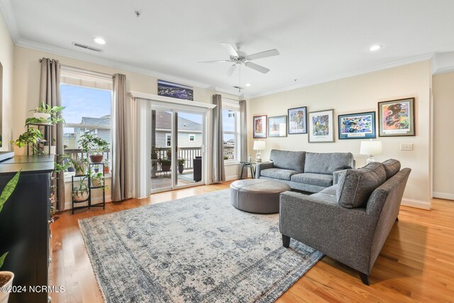 living room featuring ceiling fan, ornamental molding, and hardwood / wood-style floors