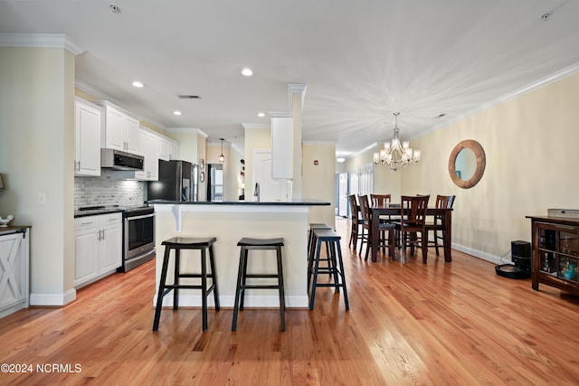 kitchen with light hardwood / wood-style flooring, a breakfast bar area, white cabinets, and appliances with stainless steel finishes