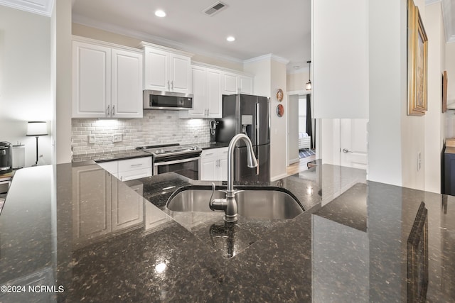 kitchen with white cabinetry, stainless steel appliances, sink, and dark stone countertops