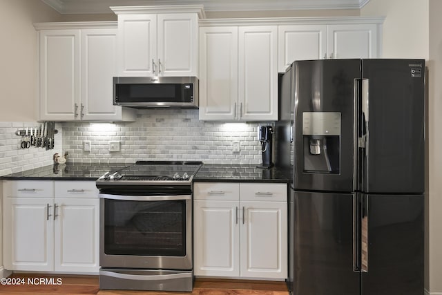 kitchen featuring white cabinetry, appliances with stainless steel finishes, tasteful backsplash, and dark stone countertops