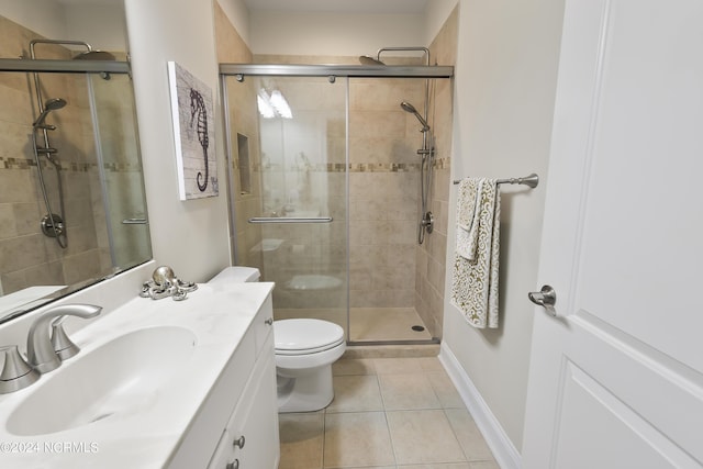 bathroom featuring tile patterned flooring, vanity, a shower with door, and toilet