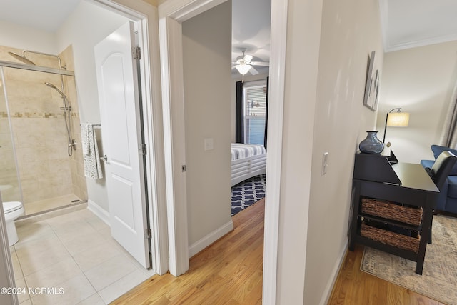 corridor with light tile patterned floors and ornamental molding