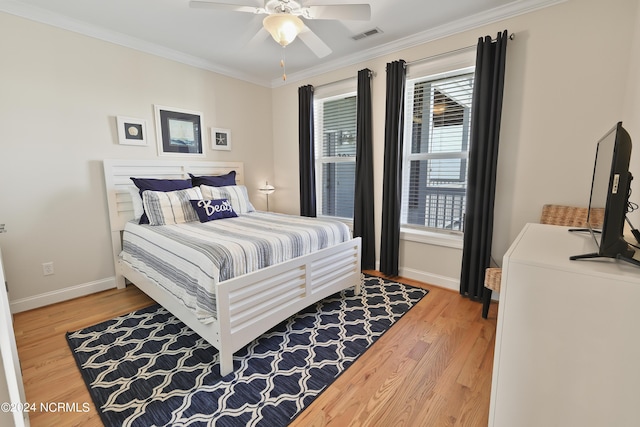 bedroom featuring hardwood / wood-style flooring, ornamental molding, and ceiling fan