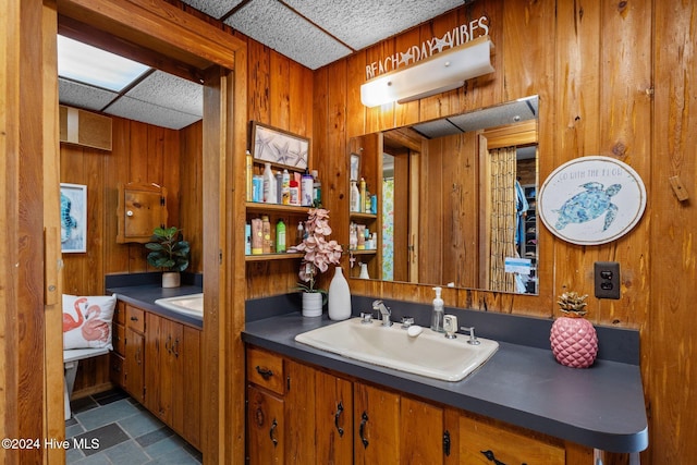 bathroom with vanity and wood walls