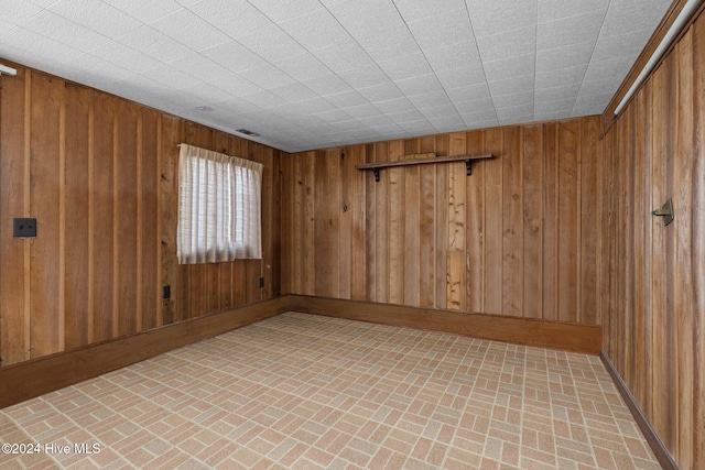 unfurnished room featuring wood walls