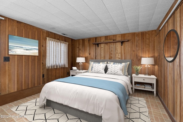 bedroom featuring wooden walls