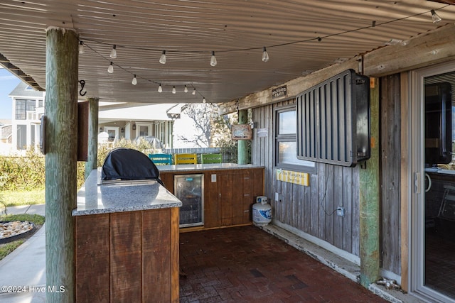 view of patio with an outdoor kitchen, area for grilling, and wine cooler