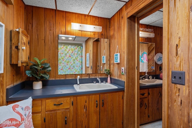 kitchen with wooden walls, sink, and a textured ceiling