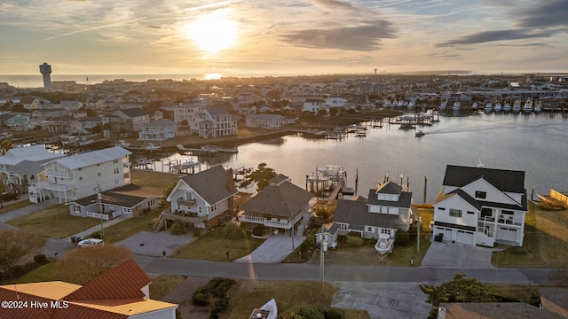 aerial view at dusk featuring a water view