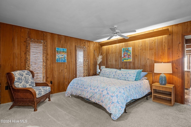 carpeted bedroom with ceiling fan and wooden walls