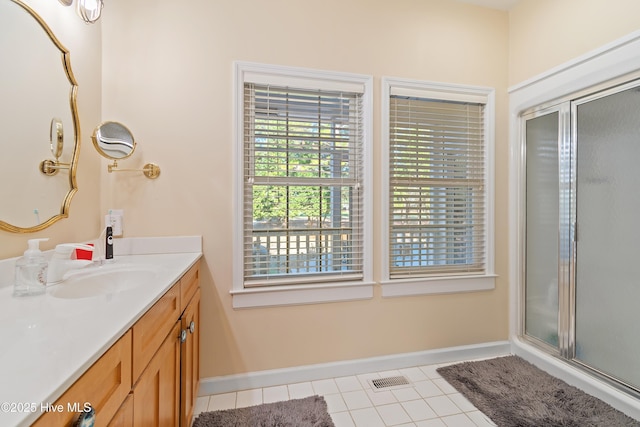 bathroom featuring tile patterned floors, vanity, and an enclosed shower