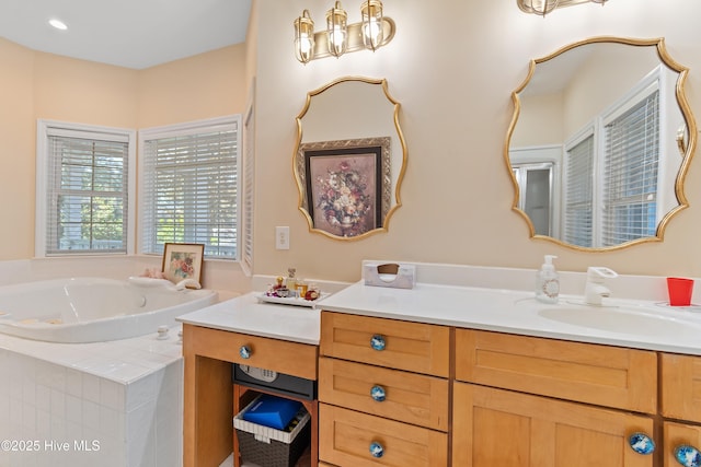 bathroom with vanity and tiled tub