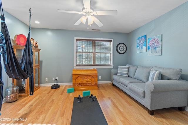 exercise room with ceiling fan and wood-type flooring