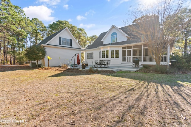 rear view of house featuring a lawn, a patio area, a sunroom, and central air condition unit