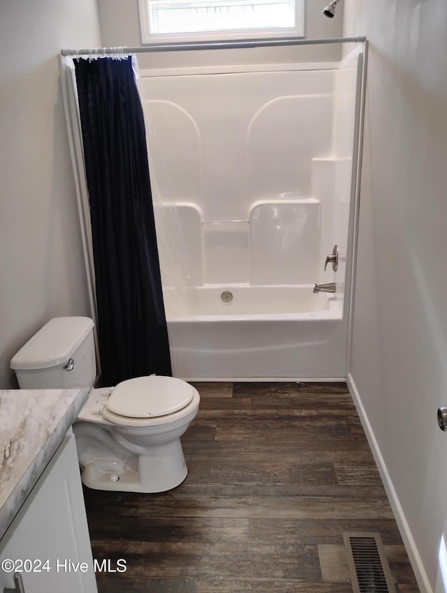 full bathroom featuring hardwood / wood-style flooring, vanity, toilet, and shower / bathtub combination with curtain