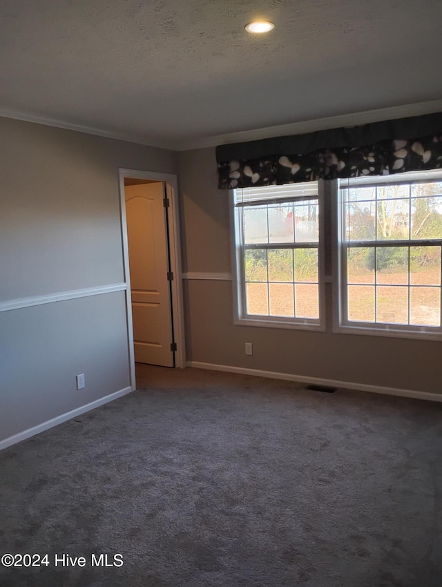 carpeted empty room featuring a textured ceiling