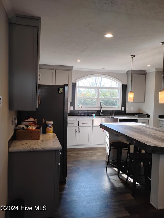 kitchen with dark hardwood / wood-style flooring, decorative light fixtures, ornamental molding, and sink