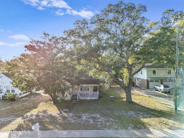 view of front of home featuring a front yard, a porch, and a garage