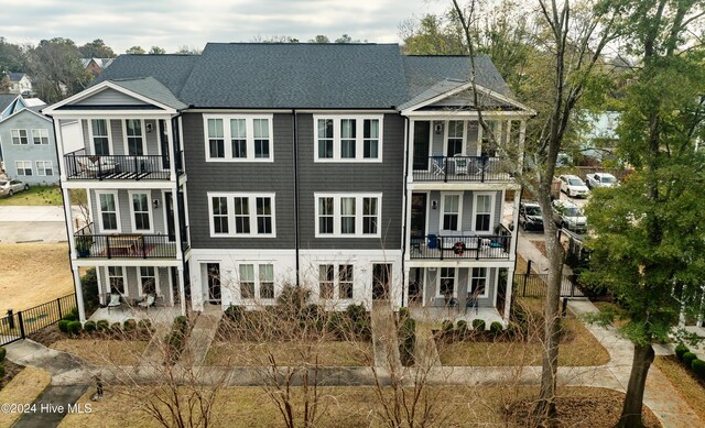 rear view of house with a patio and a balcony