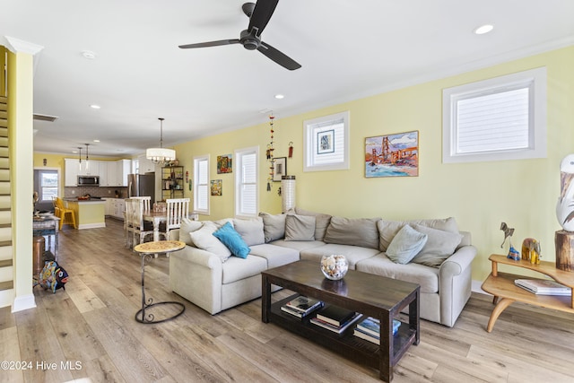 living room with ceiling fan, light hardwood / wood-style floors, and ornamental molding