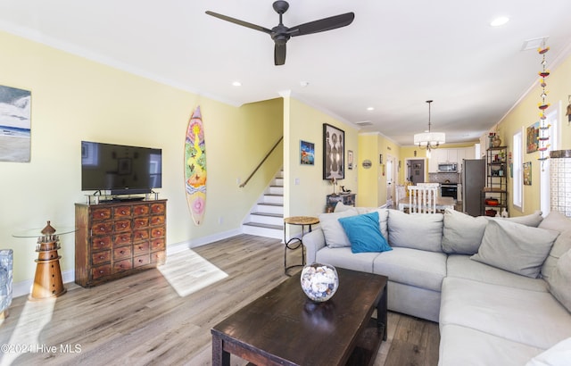 living room with hardwood / wood-style floors, ceiling fan, and crown molding