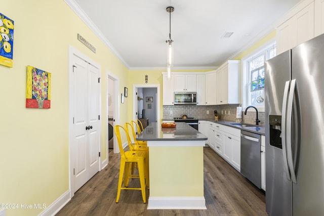 kitchen with a center island, dark wood-type flooring, white cabinets, sink, and appliances with stainless steel finishes