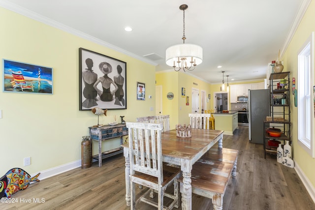 dining room featuring a notable chandelier, dark hardwood / wood-style flooring, and crown molding