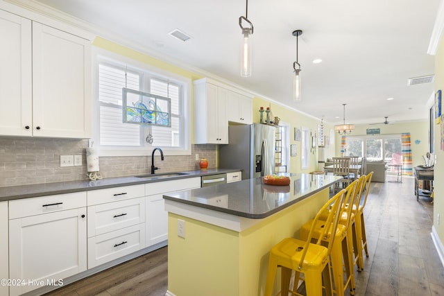 kitchen with pendant lighting, a kitchen island, dark wood-type flooring, and sink