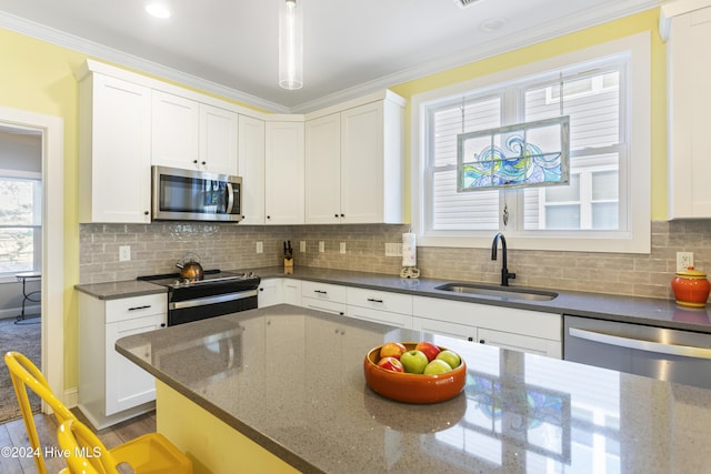 kitchen featuring stainless steel appliances, white cabinetry, and sink