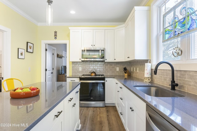 kitchen featuring white cabinets, crown molding, sink, dark stone countertops, and appliances with stainless steel finishes