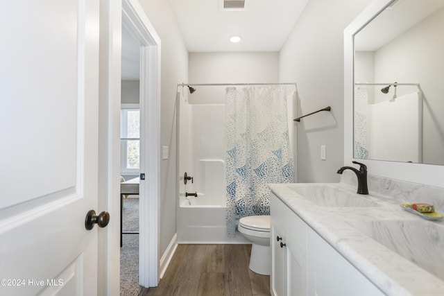 full bathroom with hardwood / wood-style flooring, vanity, toilet, and shower / tub combo with curtain