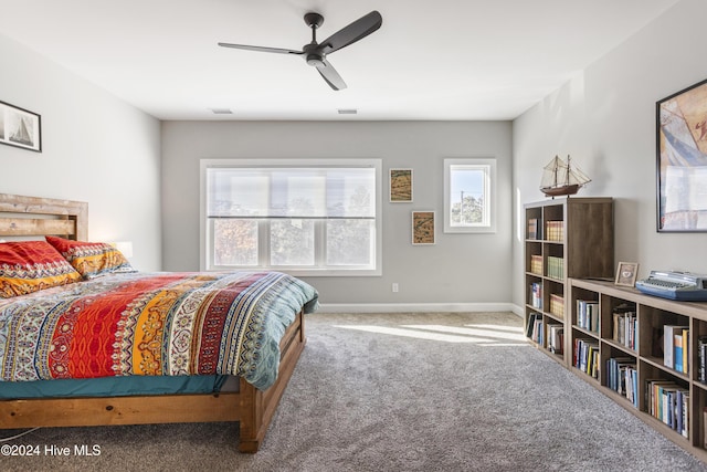 carpeted bedroom featuring multiple windows and ceiling fan