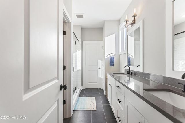 bathroom with tile patterned flooring, a wealth of natural light, vanity, and walk in shower