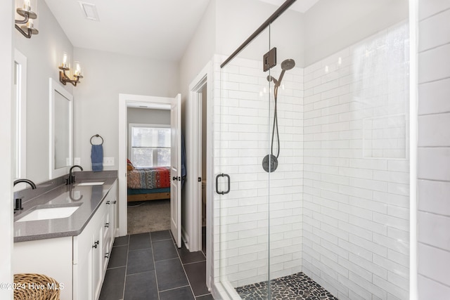 bathroom with tile patterned flooring, vanity, and walk in shower