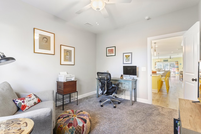 carpeted office space with ceiling fan