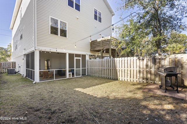 back of property with a sunroom and central air condition unit