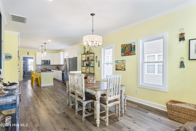 dining area featuring a healthy amount of sunlight, light wood-type flooring, and ornamental molding